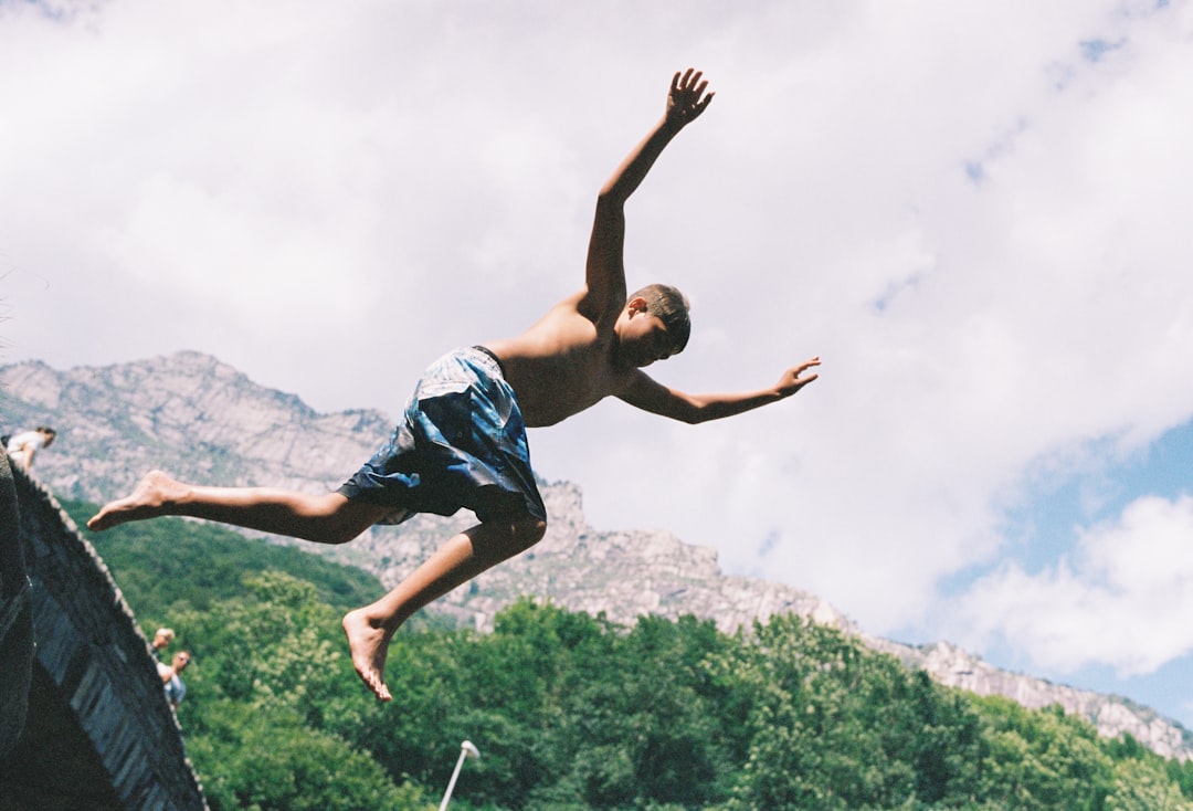 A man is jumping off a boat into the water